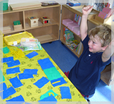 child putting his hands up in class